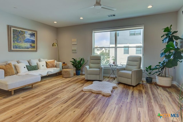 living room with ceiling fan and light wood-type flooring