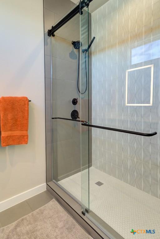 bathroom with tile patterned flooring and a shower with door