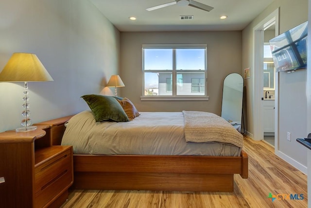 bedroom with sink, light hardwood / wood-style flooring, and ceiling fan