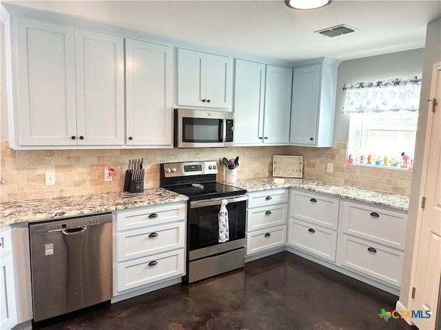 305 W Denver Ave, Seadrift, TX 77983 - kitchen featuring appliances with stainless steel finishes, concrete flooring, backsplash, light stone counters, and white cabinets