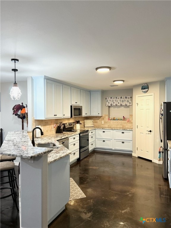 kitchen featuring stainless steel appliances, kitchen peninsula, sink, backsplash, and pendant lighting