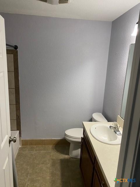 bathroom with tile patterned floors, baseboards, toilet, and vanity