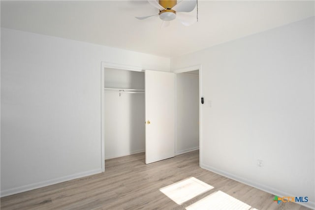 unfurnished bedroom featuring a closet, light hardwood / wood-style flooring, and ceiling fan