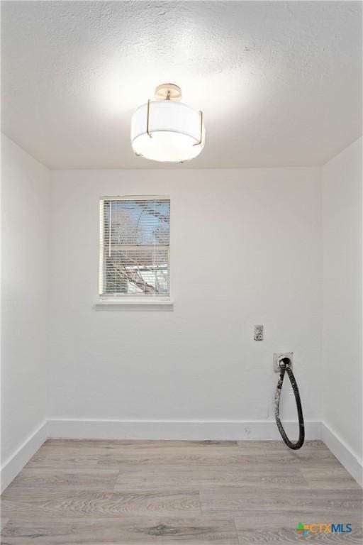 unfurnished room featuring light hardwood / wood-style floors and a textured ceiling