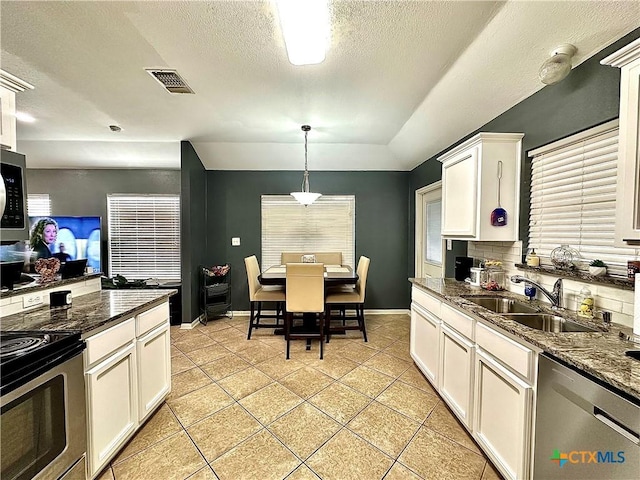 kitchen with light tile patterned floors, a sink, visible vents, white cabinetry, and appliances with stainless steel finishes