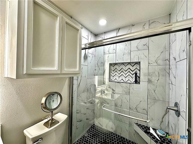 full bath featuring toilet, a textured ceiling, and a marble finish shower