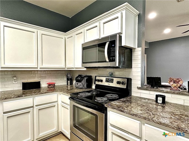 kitchen with appliances with stainless steel finishes, white cabinetry, dark stone countertops, and tasteful backsplash