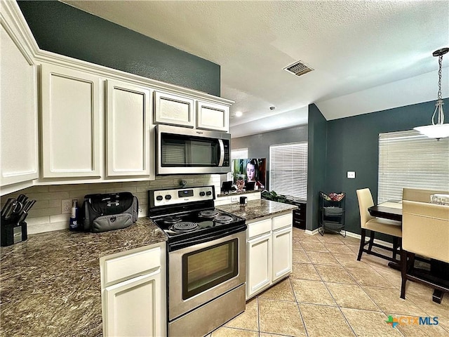 kitchen with light tile patterned floors, stainless steel appliances, visible vents, decorative backsplash, and white cabinets