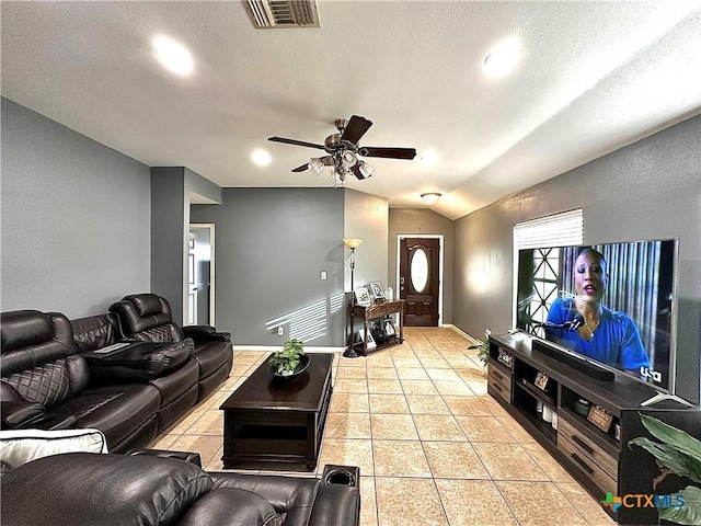 living room featuring light tile patterned floors, visible vents, a ceiling fan, vaulted ceiling, and baseboards