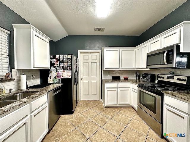 kitchen featuring light tile patterned floors, stainless steel appliances, visible vents, backsplash, and white cabinets