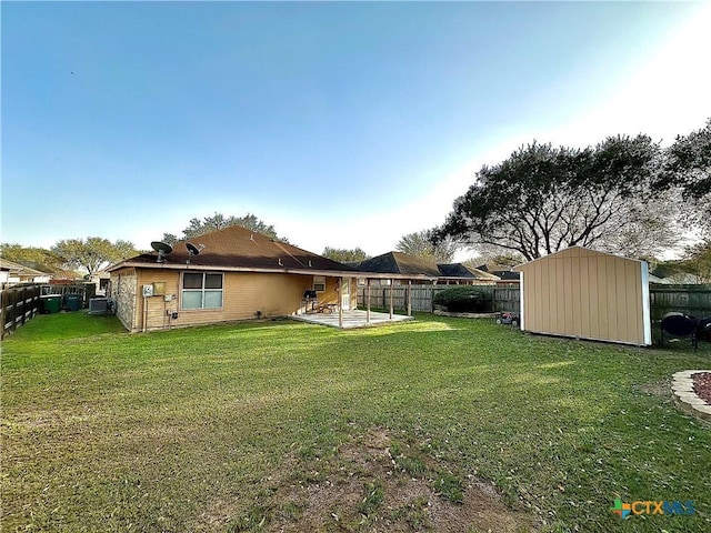 view of yard with a storage shed, a patio, an outdoor structure, and a fenced backyard