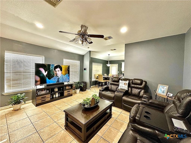 home theater room featuring ceiling fan, visible vents, and light tile patterned flooring