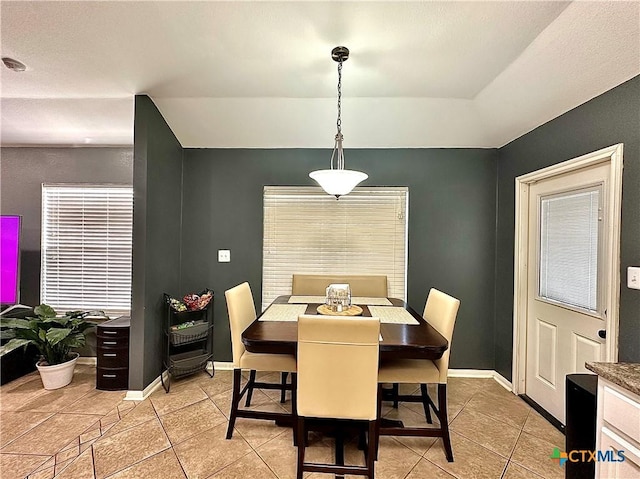 dining area featuring light tile patterned floors and baseboards