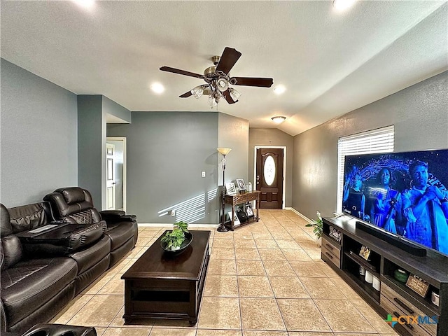 living area featuring light tile patterned floors, ceiling fan, vaulted ceiling, a textured ceiling, and baseboards