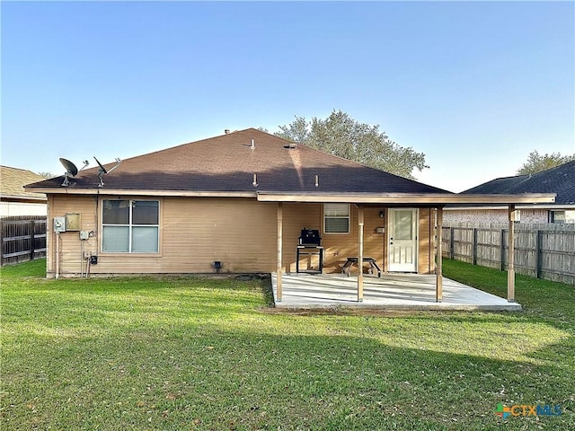 rear view of house with a lawn, a patio area, and fence private yard