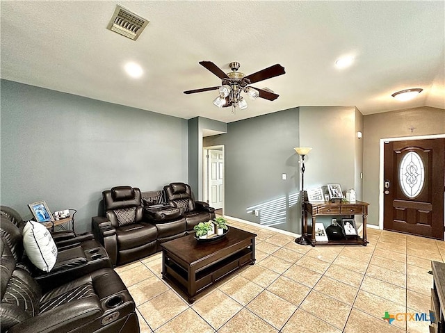 living area with light tile patterned floors, baseboards, visible vents, ceiling fan, and vaulted ceiling