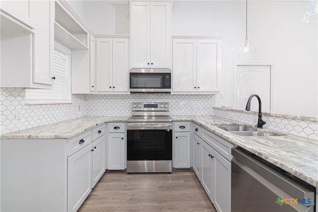 168 Navarro Xing, Seguin, TX 78155 - kitchen with stainless steel appliances, a sink, tasteful backsplash, light stone countertops, and hanging light fixtures