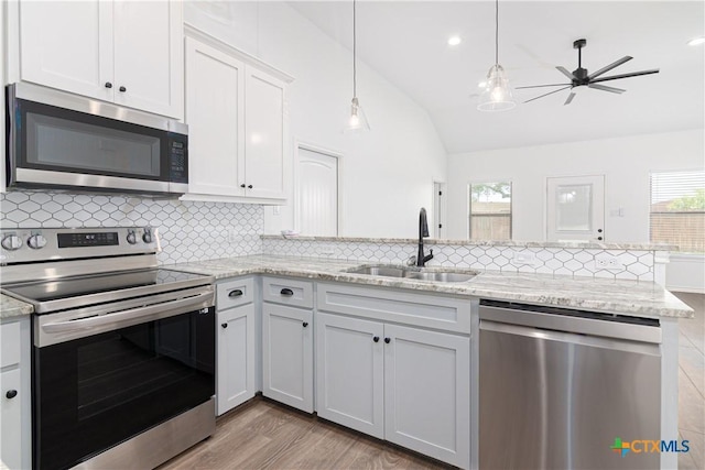 168 Navarro Xing, Seguin, TX 78155 - kitchen with stainless steel appliances, a sink, a peninsula, lofted ceiling, and backsplash