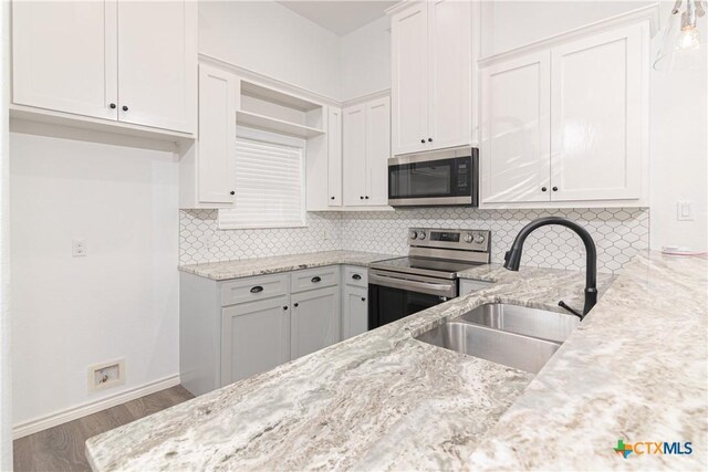 168 Navarro Xing, Seguin, TX 78155 - kitchen featuring appliances with stainless steel finishes, a sink, light stone counters, open shelves, and white cabinets