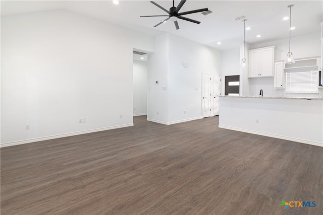 168 Navarro Xing, Seguin, TX 78155 - unfurnished living room featuring a ceiling fan, dark wood-style floors, vaulted ceiling, baseboards, and recessed lighting