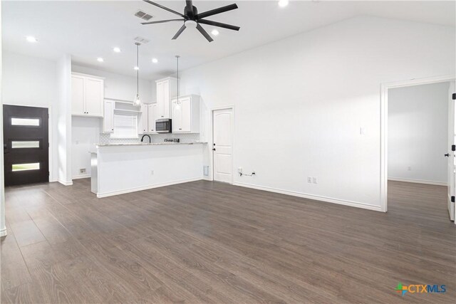 168 Navarro Xing, Seguin, TX 78155 - unfurnished living room with ceiling fan, recessed lighting, high vaulted ceiling, dark wood-style flooring, and baseboards