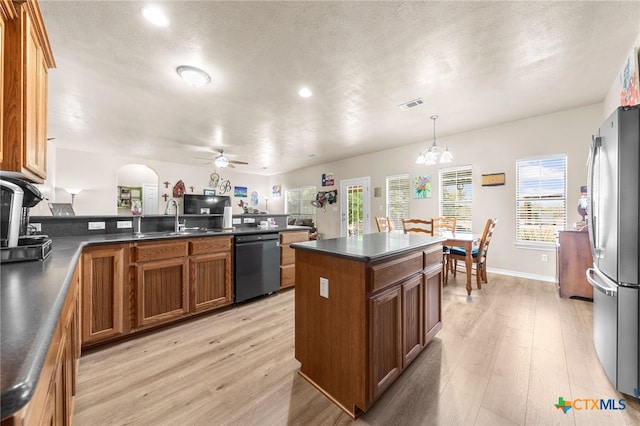 kitchen with sink, light hardwood / wood-style flooring, stainless steel fridge, pendant lighting, and black dishwasher