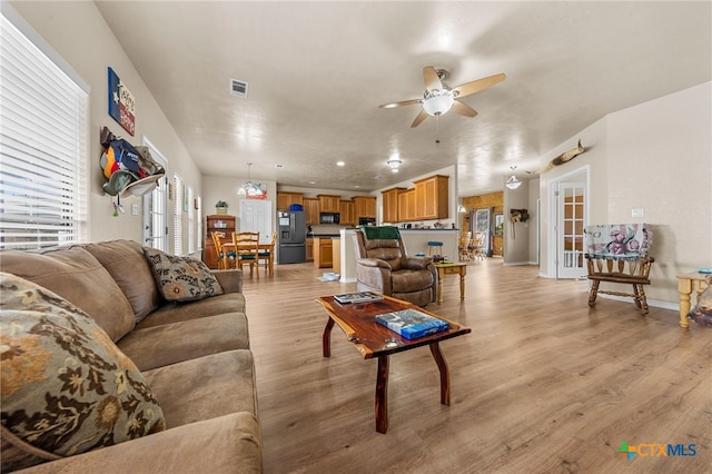 living room featuring ceiling fan and light hardwood / wood-style flooring