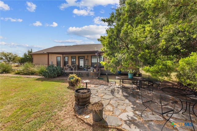 back of property with a patio and a lawn