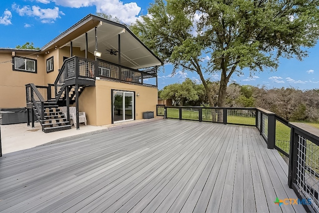deck with stairs and a hot tub