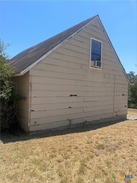 view of side of home with a yard