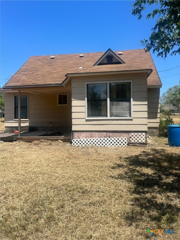 rear view of property featuring a yard