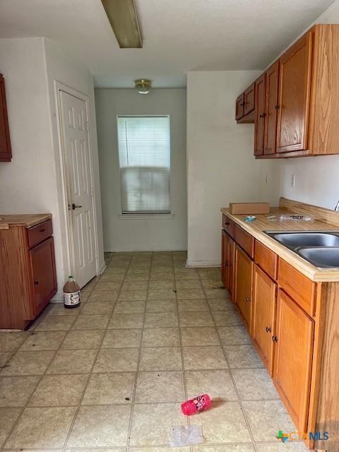 501 San Antonio St, Marlin, TX 76661 - kitchen featuring brown cabinetry and light countertops