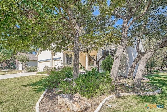 obstructed view of property featuring a garage and a front lawn