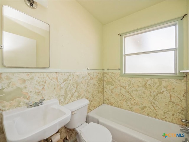 bathroom with sink, a bath, and toilet