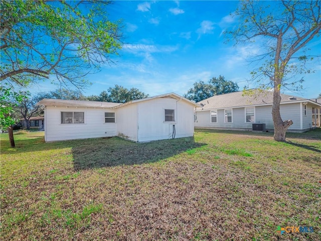 back of property with a lawn and central air condition unit