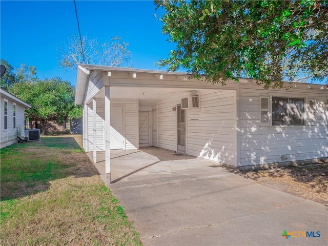 view of front of house with a carport, central air condition unit, and a front yard