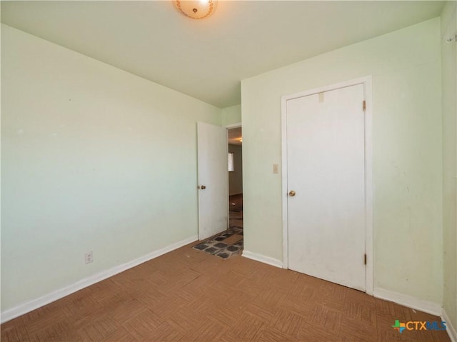 unfurnished bedroom featuring parquet flooring