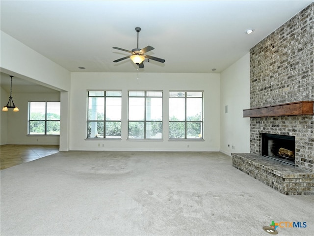 unfurnished living room with light carpet, ceiling fan, and a fireplace