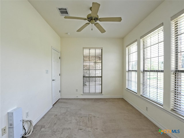 carpeted empty room with ceiling fan and a healthy amount of sunlight