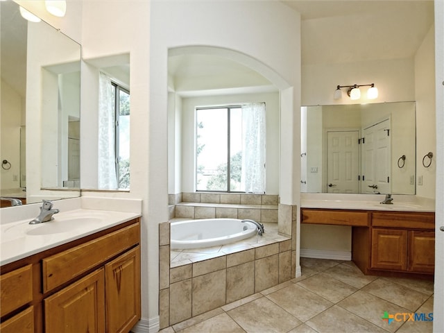 bathroom featuring tiled bath, tile patterned flooring, and vanity