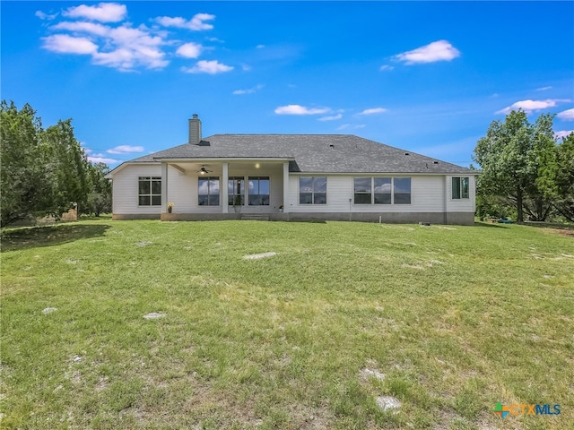 rear view of property with a yard