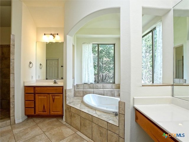 bathroom featuring vanity, tile patterned flooring, a healthy amount of sunlight, and separate shower and tub