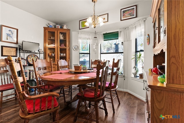 dining area with dark hardwood / wood-style flooring and a chandelier