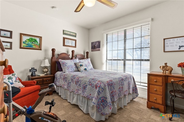 carpeted bedroom with ceiling fan and multiple windows