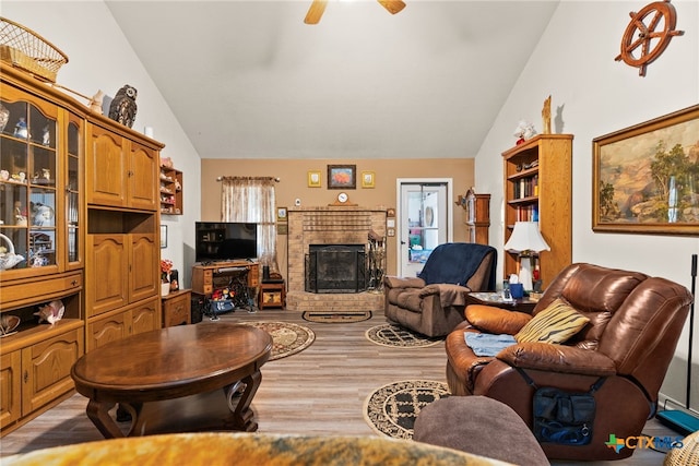 living room with ceiling fan, a fireplace, vaulted ceiling, and hardwood / wood-style floors