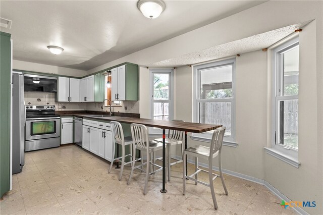 501 Geri Dr, Copperas Cove, TX 76522 - kitchen featuring dark countertops, stainless steel appliances, tasteful backsplash, and light floors