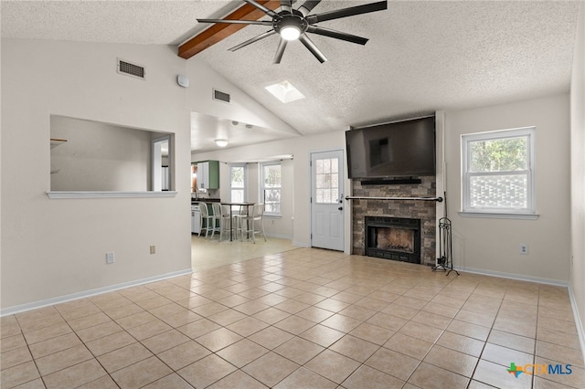 501 Geri Dr, Copperas Cove, TX 76522 - unfurnished living room with ceiling fan, a textured ceiling, a fireplace, tile patterned floors, and a skylight