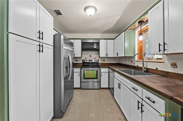 501 Geri Dr, Copperas Cove, TX 76522 - kitchen featuring butcher block countertops, appliances with stainless steel finishes, decorative backsplash, and white cabinetry