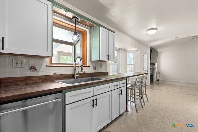 501 Geri Dr, Copperas Cove, TX 76522 - kitchen featuring wood counters, dishwasher, tasteful backsplash, white cabinets, and hanging light fixtures