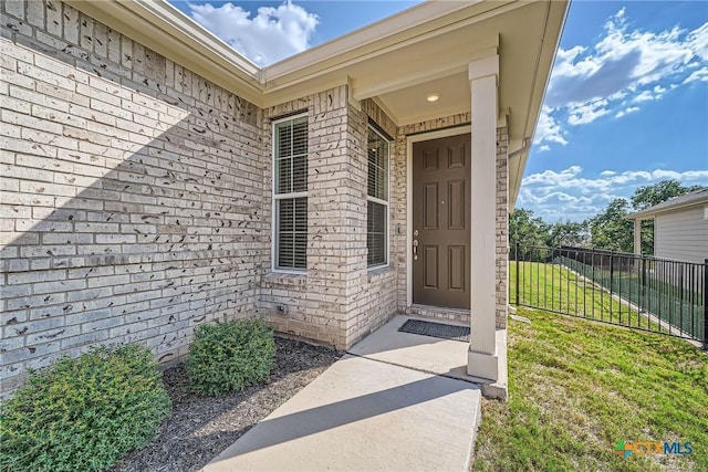 doorway to property featuring a lawn